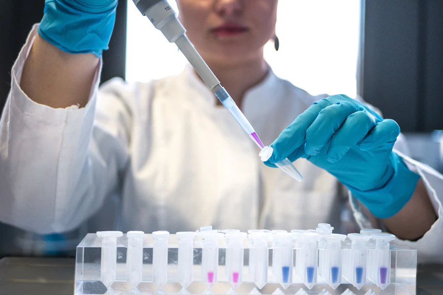 A laboratory technician pipetting a blood sample into a tube